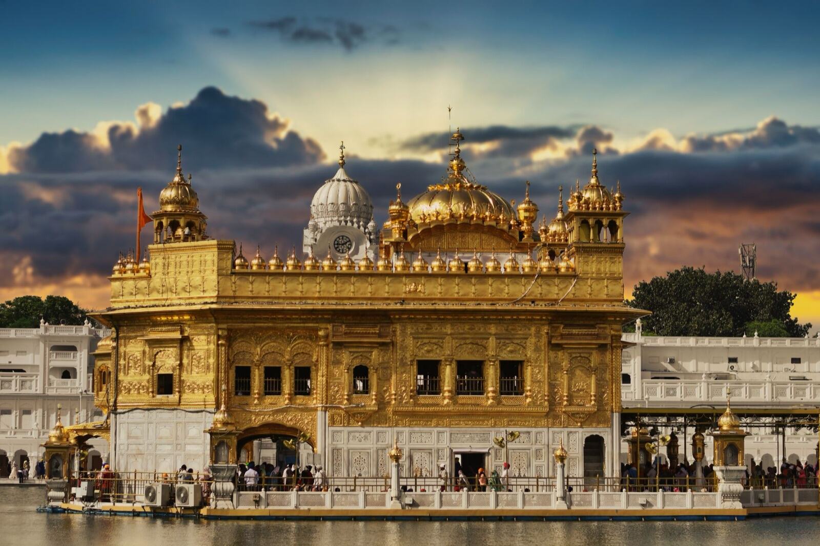 The Golden Temple at Amritsar at dusk, pilgrims crossing the causeway